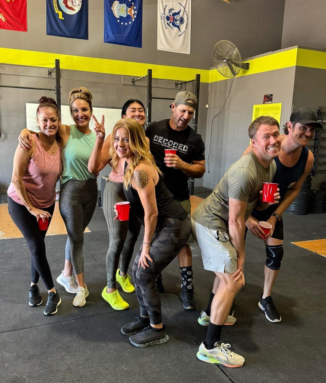 Group of members posing together with red cups at social hour
