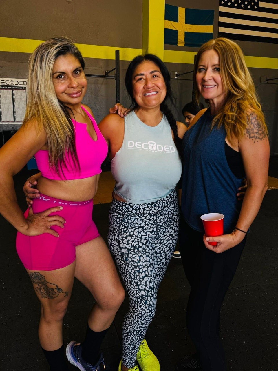 Three members posing together in front of the rig