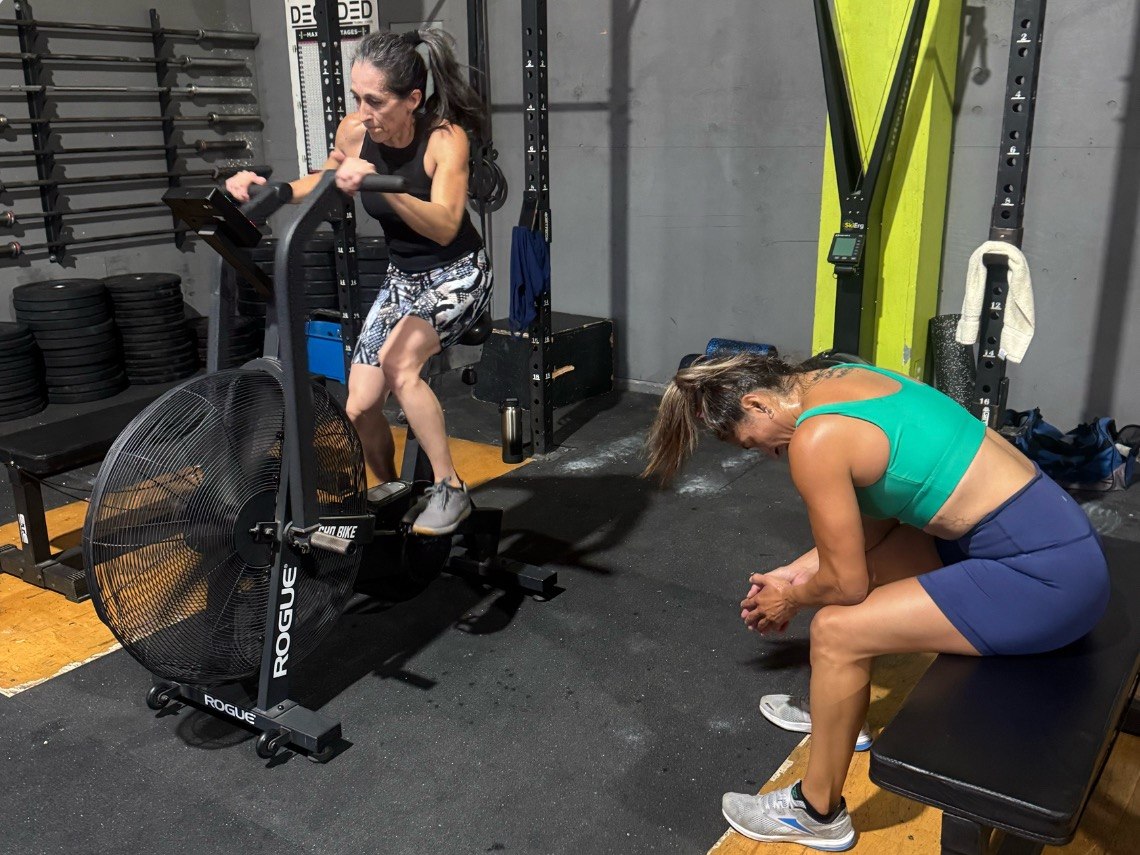 Two members on the air bike and bench between rounds