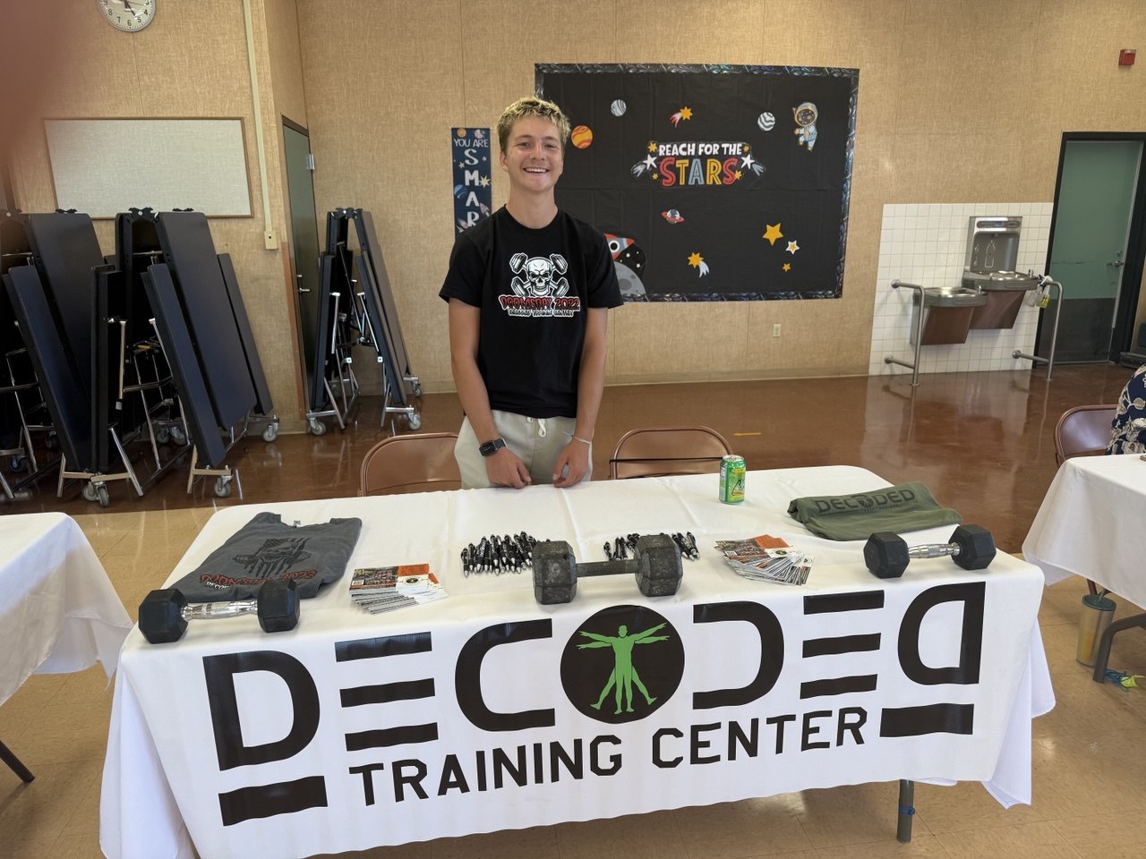 Decoded team at a community outreach booth with the banner