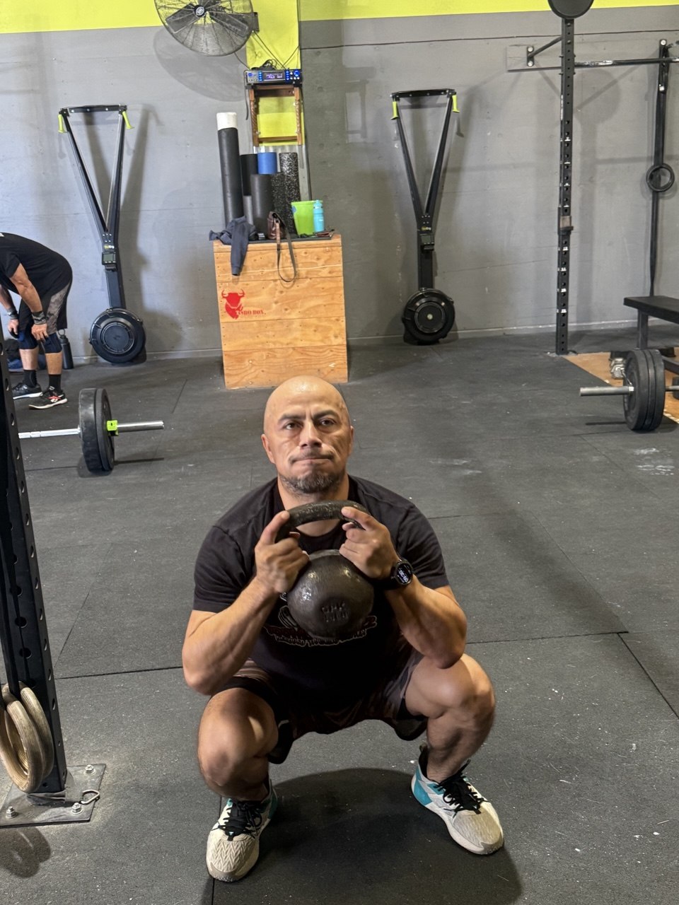 Member deep in a goblet squat with a kettlebell