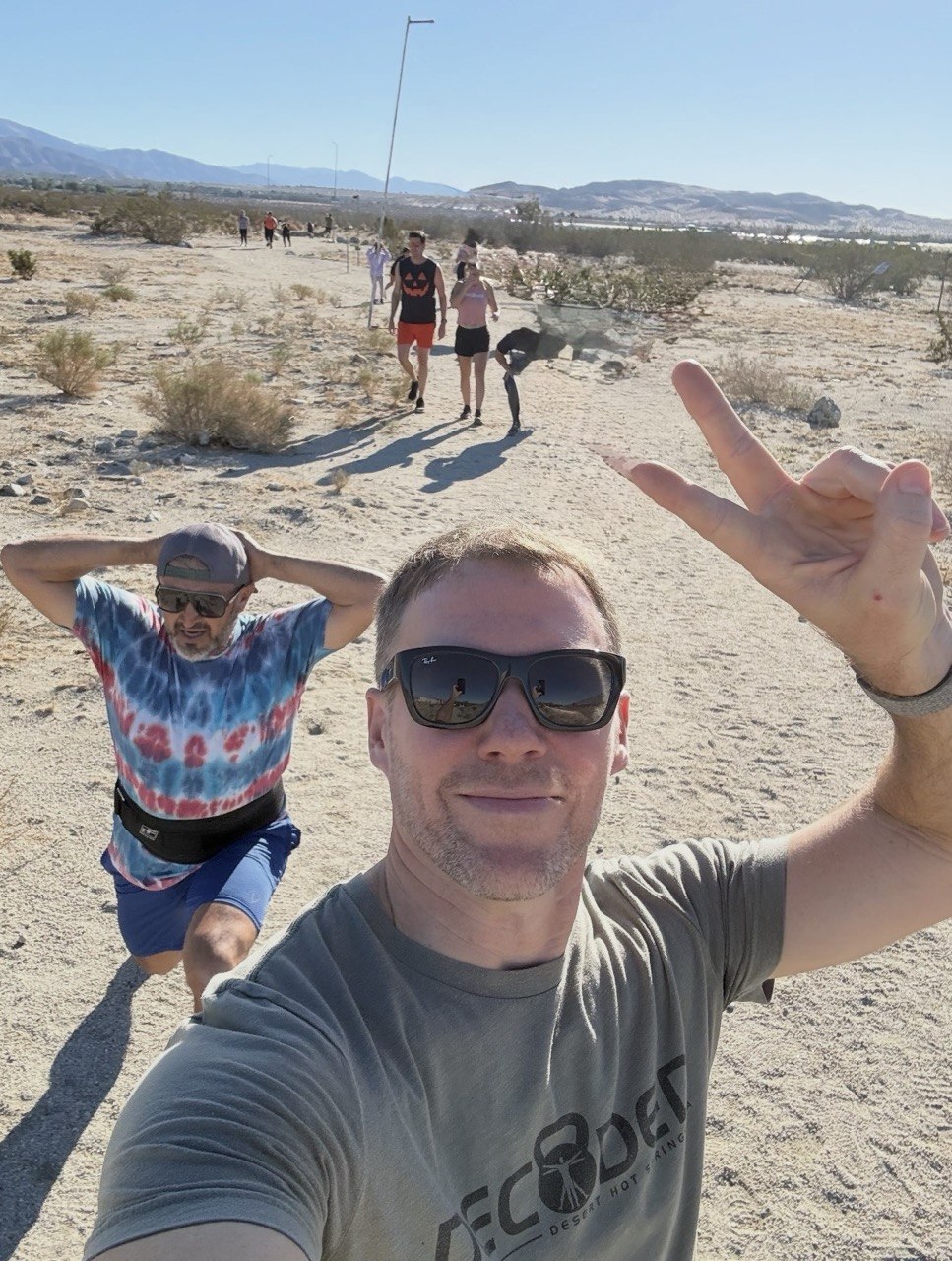 Members on a desert trail run, selfie with a peace sign