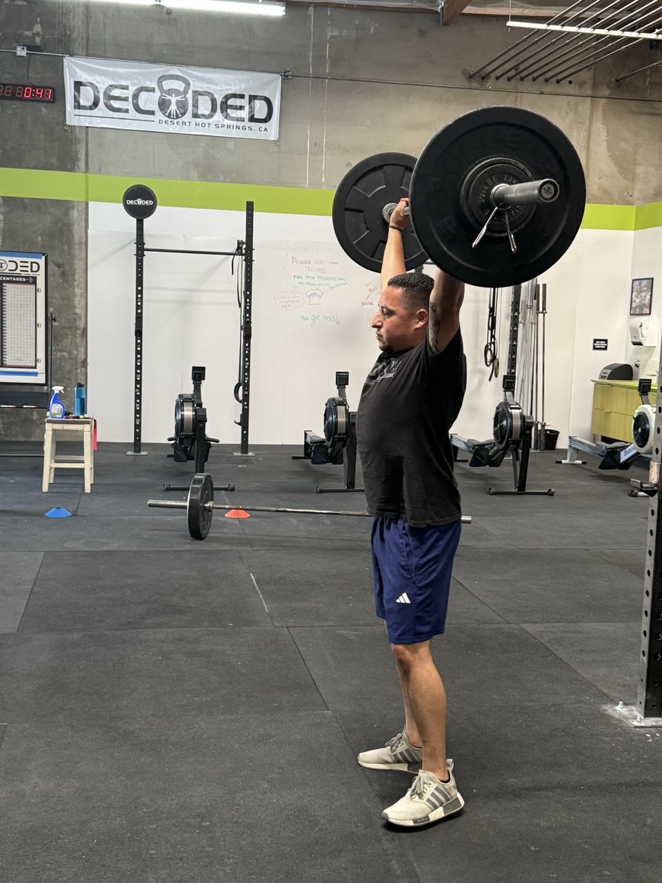 Member locking out a barbell overhead