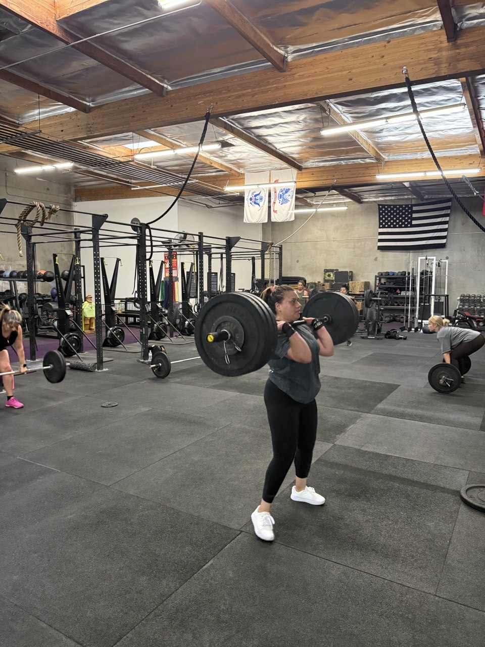 Member holding a barbell in the front-rack position
