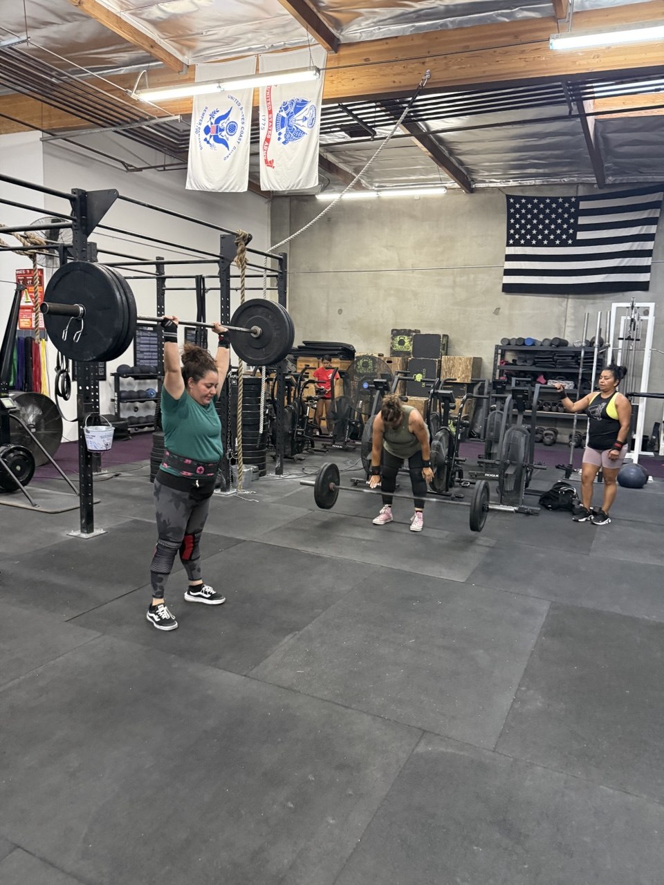 Member locking out a barbell overhead