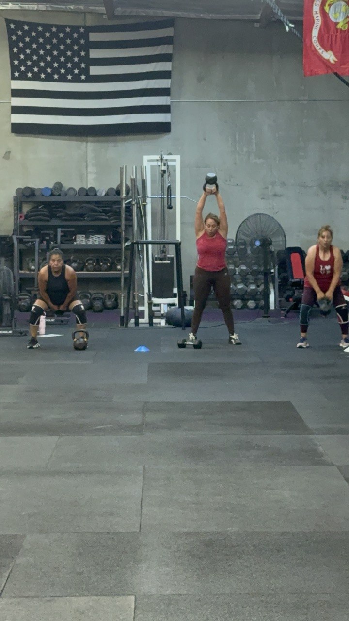 Members at the top of their kettlebell swings
