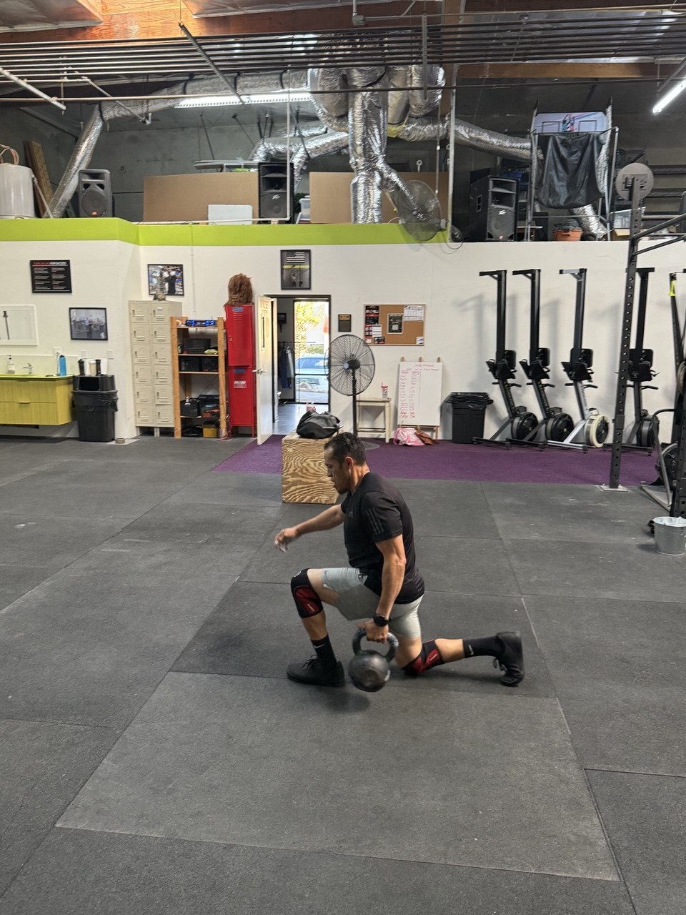Member working a kettlebell lunge on the floor