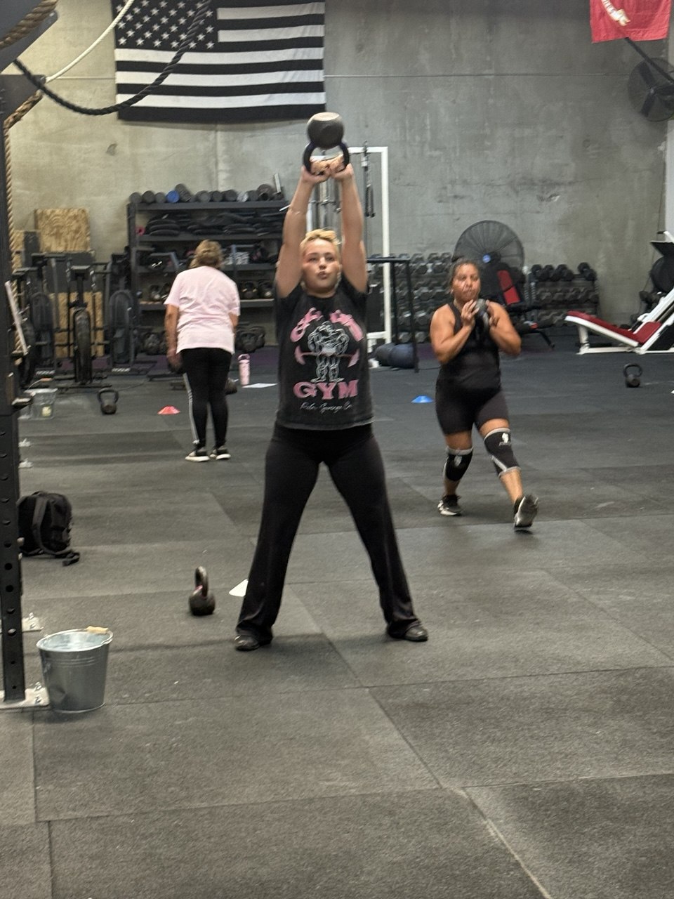 Member driving through a two-handed kettlebell swing