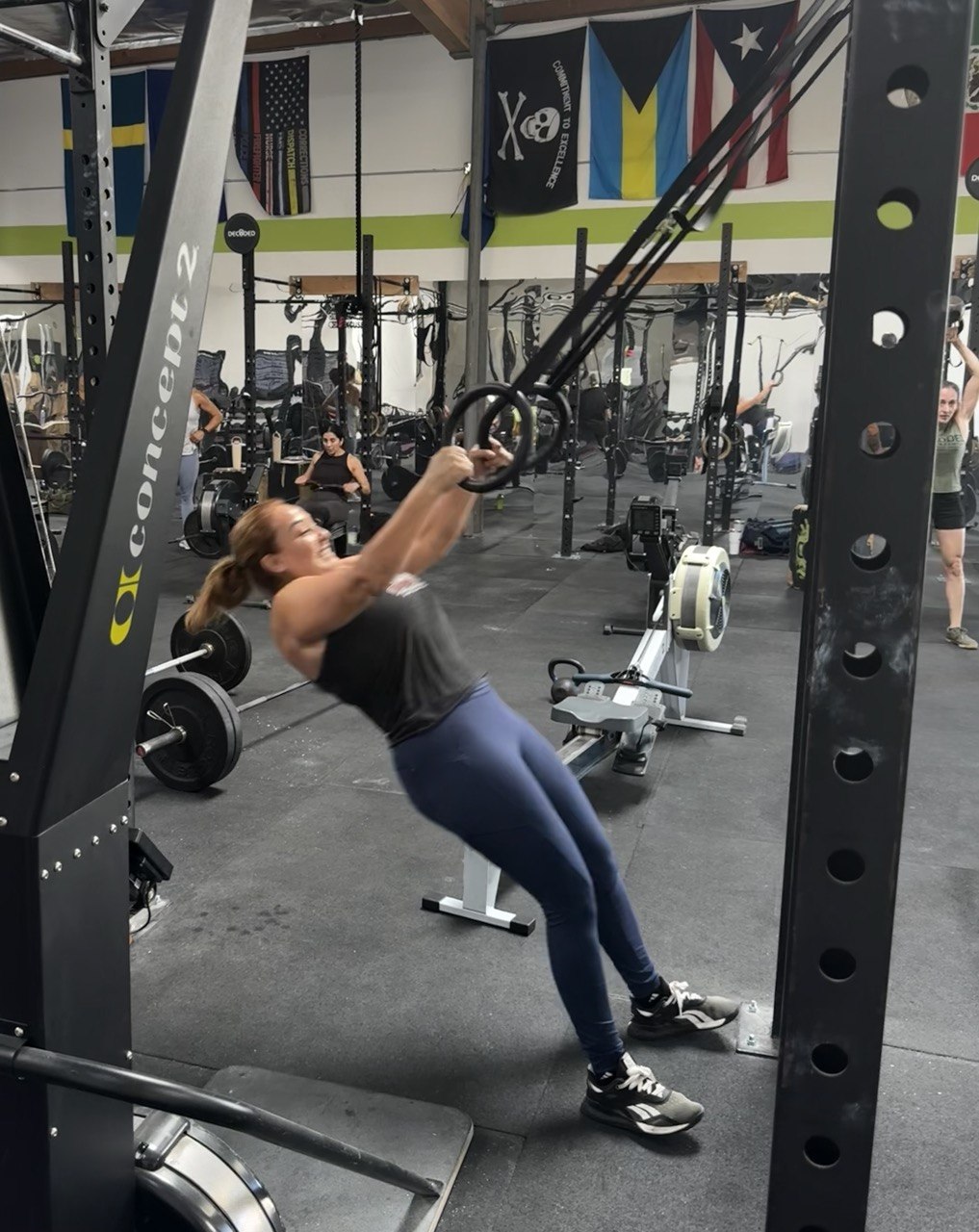 Member leaning back on the gymnastic rings mid-row during a training session