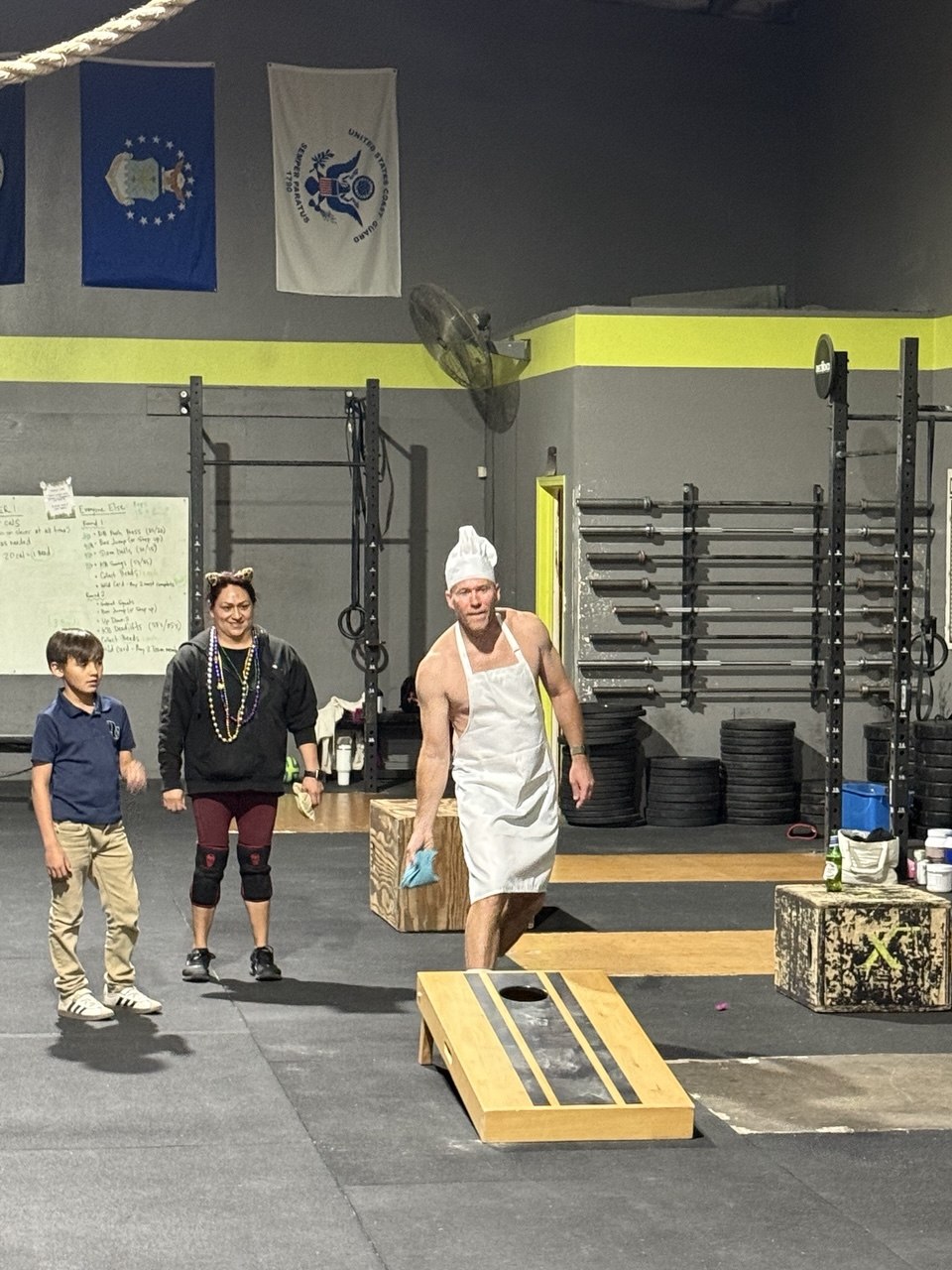 First Friday chef-costume member playing cornhole
